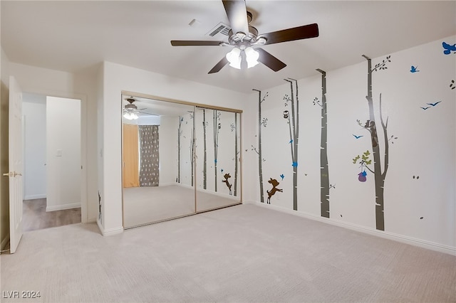 unfurnished bedroom with a closet, light colored carpet, and ceiling fan