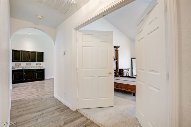 hall featuring lofted ceiling and light wood-type flooring