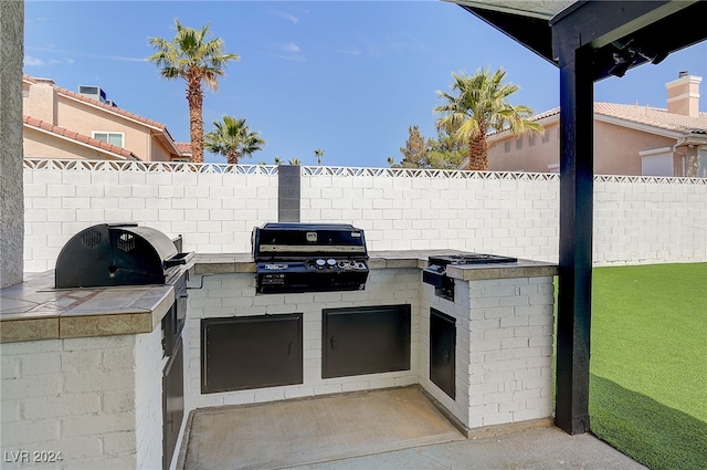 view of patio featuring exterior kitchen and grilling area