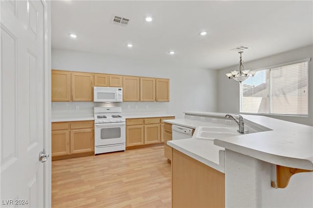 kitchen with white appliances, sink, hanging light fixtures, light wood-type flooring, and a notable chandelier