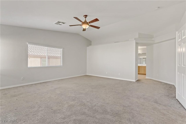 spare room featuring ceiling fan, lofted ceiling, and light carpet