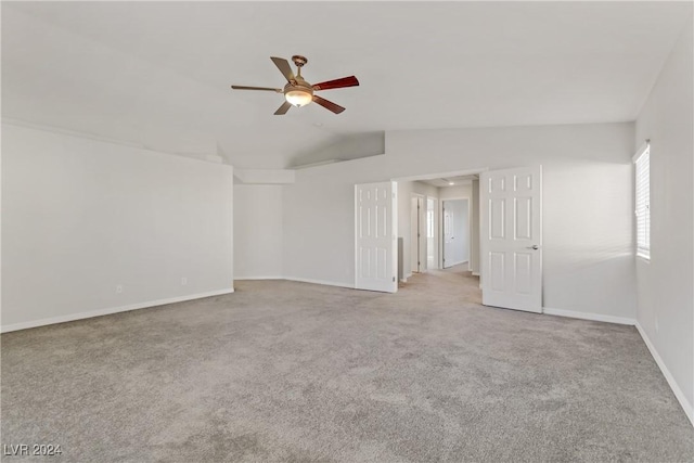 unfurnished room with ceiling fan, light colored carpet, and vaulted ceiling