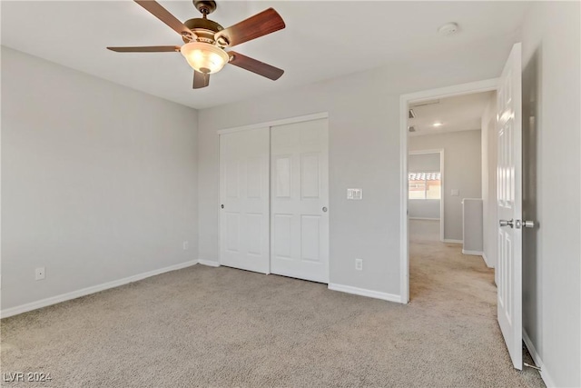 unfurnished bedroom featuring ceiling fan, light colored carpet, and a closet