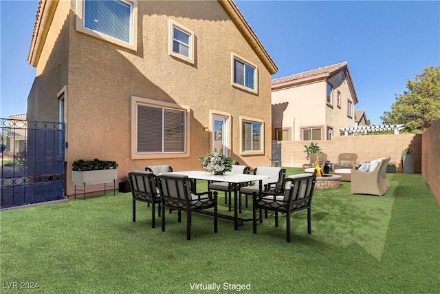 rear view of house featuring a lawn and an outdoor fire pit