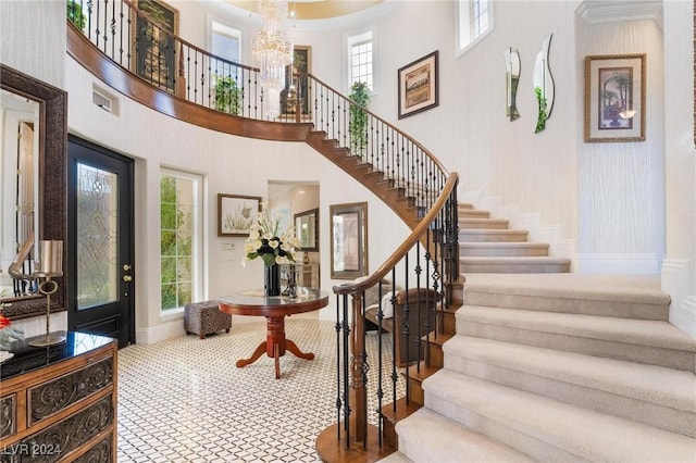 foyer entrance with a high ceiling and a notable chandelier