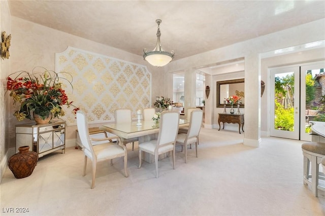 carpeted dining space with french doors