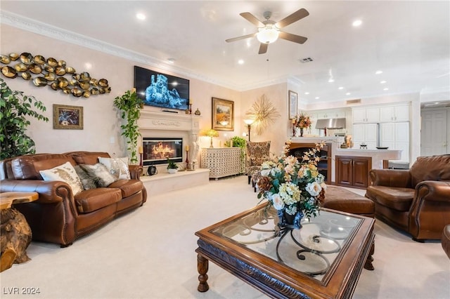 carpeted living room featuring ceiling fan and crown molding