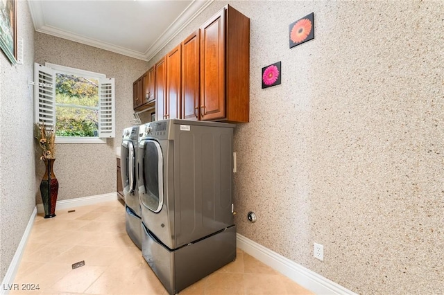 washroom with washer and dryer, light tile patterned floors, crown molding, and cabinets