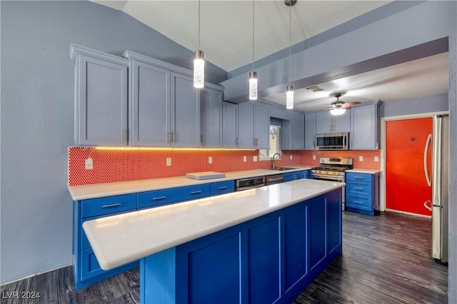 kitchen with appliances with stainless steel finishes, dark hardwood / wood-style flooring, ceiling fan, blue cabinetry, and pendant lighting