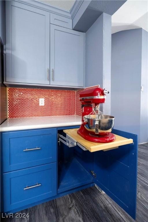 kitchen with blue cabinetry, decorative backsplash, and dark wood-type flooring