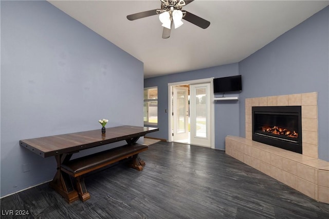 dining space with dark hardwood / wood-style floors, ceiling fan, and a tile fireplace