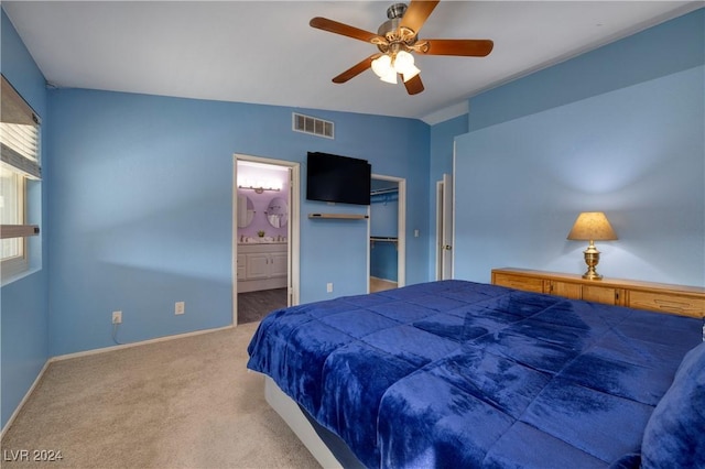 carpeted bedroom featuring ensuite bathroom, vaulted ceiling, ceiling fan, a spacious closet, and a closet