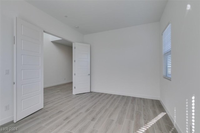 unfurnished room with light wood-type flooring