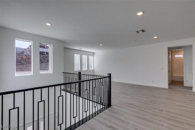 corridor with light hardwood / wood-style floors