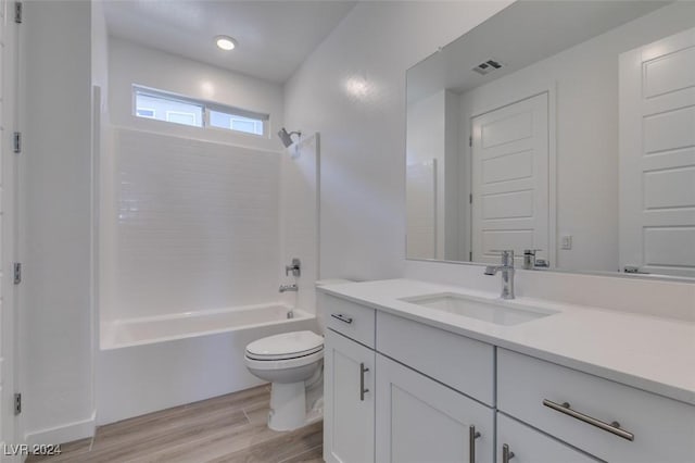 full bathroom featuring toilet, vanity, hardwood / wood-style flooring, and bathing tub / shower combination