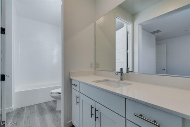 full bathroom with wood-type flooring, vanity, toilet, and shower / tub combination