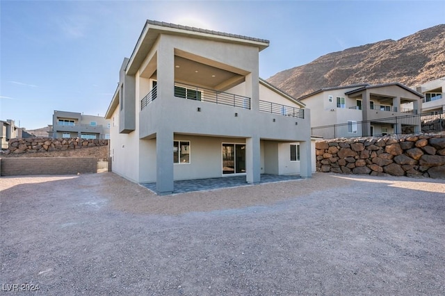 back of house featuring a mountain view and a patio