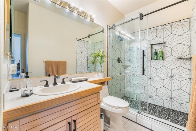 bathroom featuring tile patterned floors, vanity, toilet, and walk in shower