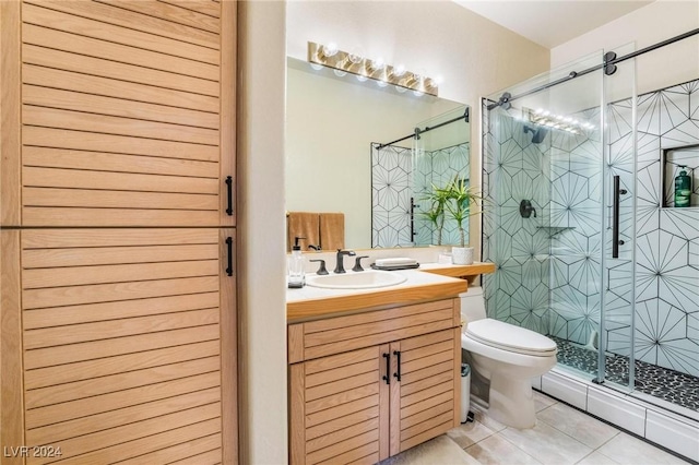 bathroom featuring tile patterned floors, vanity, a shower with shower door, and toilet