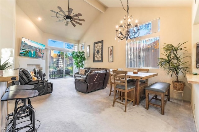 carpeted dining room featuring beamed ceiling, ceiling fan with notable chandelier, and high vaulted ceiling