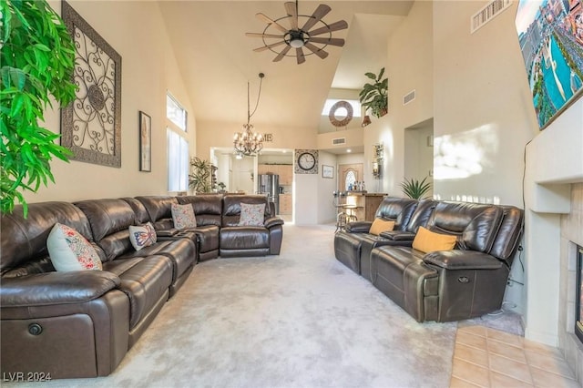 living room featuring carpet flooring, a wealth of natural light, high vaulted ceiling, and ceiling fan with notable chandelier