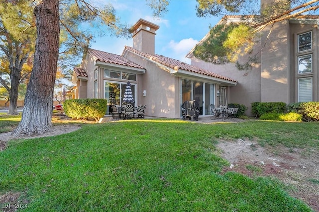 rear view of property featuring a yard and a patio