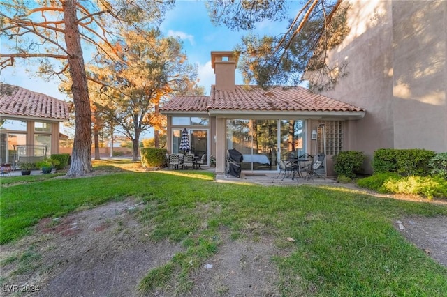 back of house with a yard and a patio