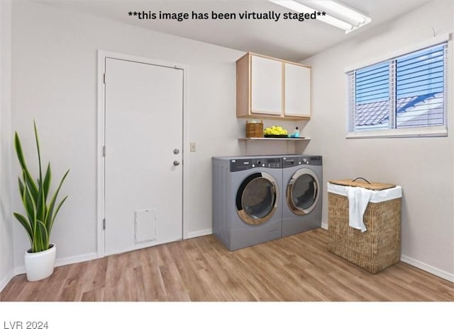 laundry area with light hardwood / wood-style floors, cabinets, and independent washer and dryer