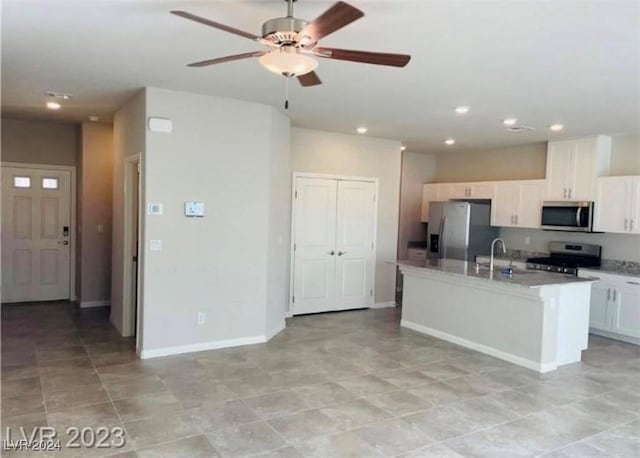 kitchen with sink, ceiling fan, an island with sink, appliances with stainless steel finishes, and white cabinetry