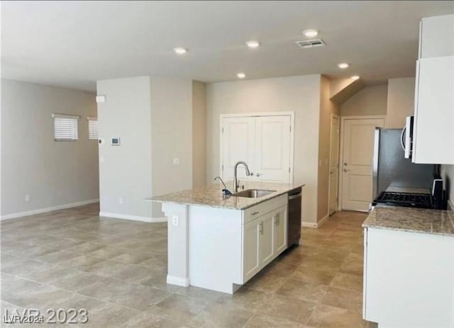 kitchen with sink, stove, black dishwasher, an island with sink, and white cabinets