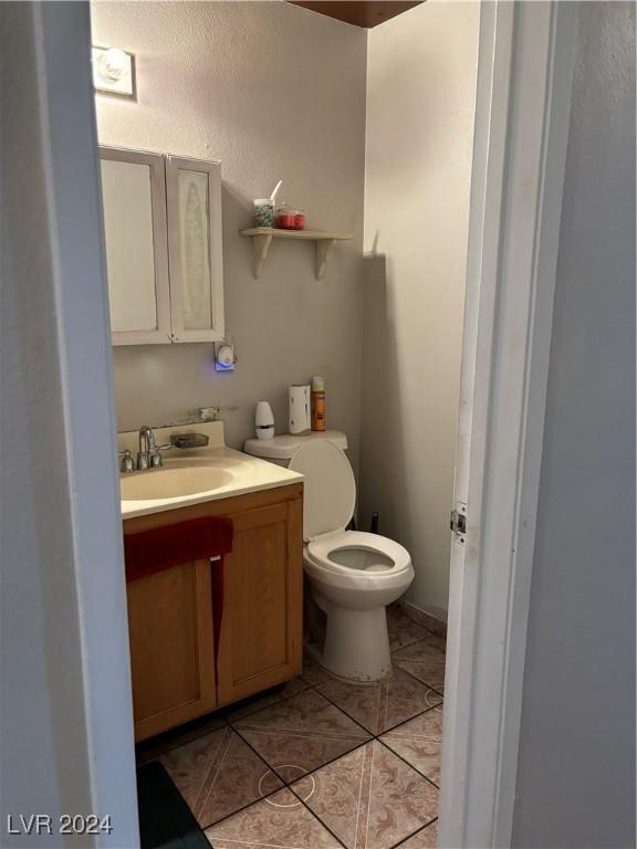 bathroom with tile patterned flooring, toilet, and vanity