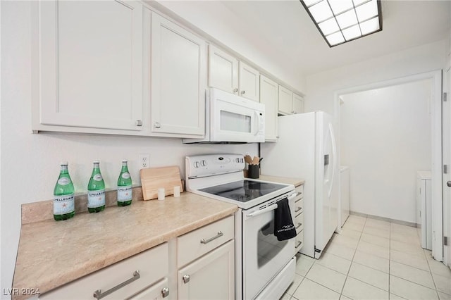 kitchen featuring white cabinets, white appliances, light tile patterned floors, and separate washer and dryer