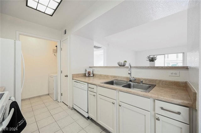 kitchen with white appliances, sink, light tile patterned floors, white cabinets, and washing machine and dryer