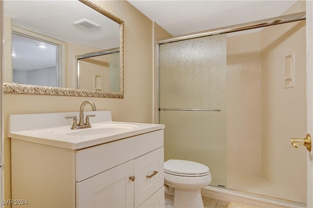 bathroom featuring tile patterned floors, vanity, toilet, and an enclosed shower