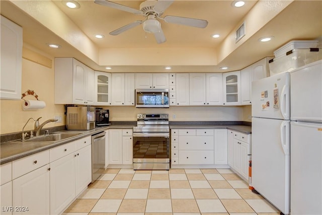 kitchen with stainless steel appliances, ceiling fan, sink, light tile patterned floors, and white cabinets