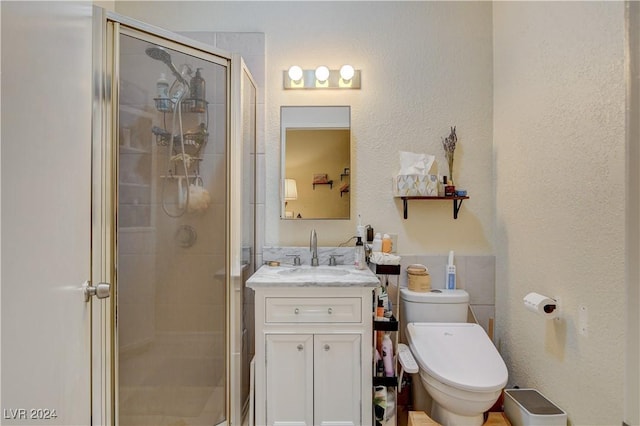 bathroom with vanity, toilet, and a shower with door