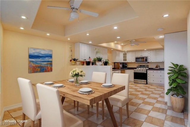 dining area featuring a tray ceiling and ceiling fan