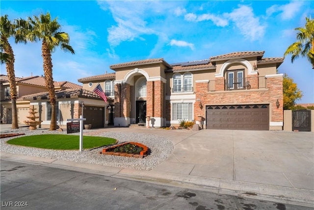 mediterranean / spanish-style house with solar panels, a garage, and a balcony