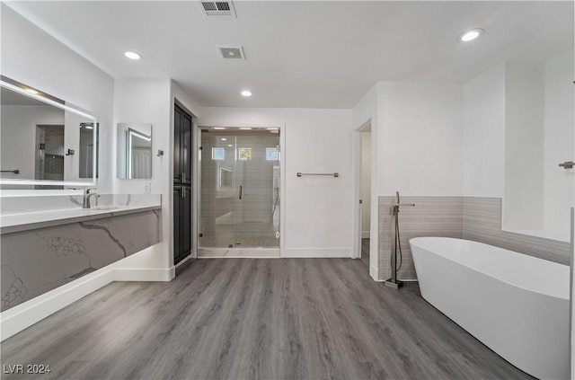 bathroom featuring wood-type flooring, vanity, and independent shower and bath