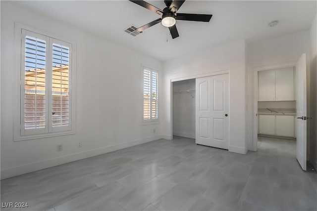 unfurnished bedroom with ceiling fan and a closet