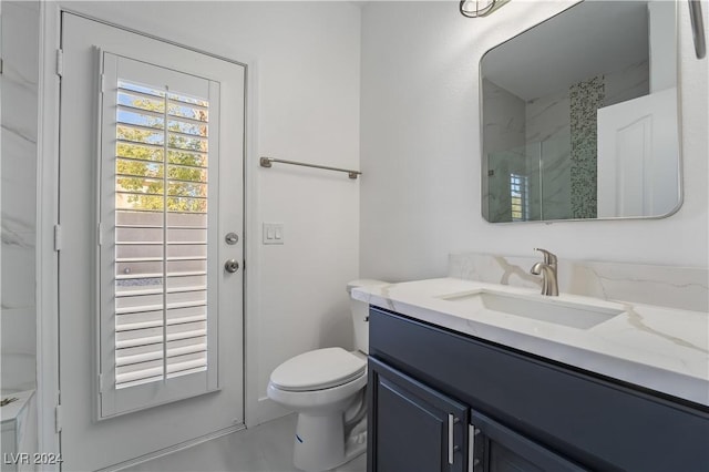 bathroom featuring vanity, toilet, and a shower