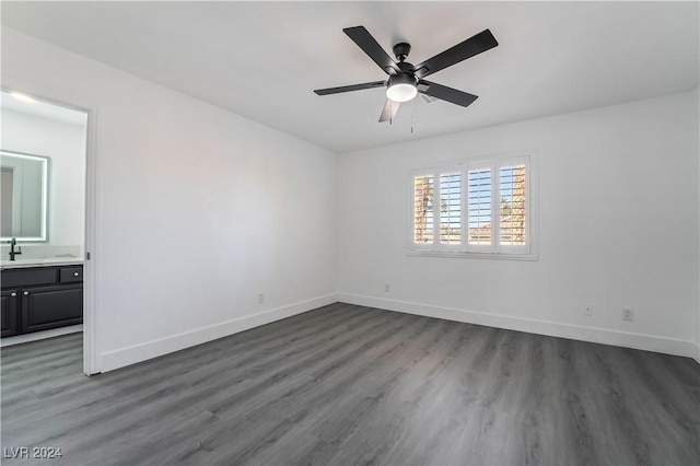 empty room featuring ceiling fan, sink, and dark wood-type flooring