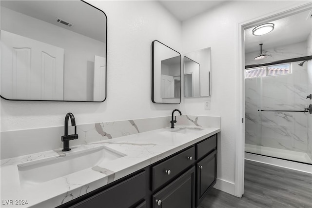 bathroom featuring hardwood / wood-style flooring, vanity, and walk in shower