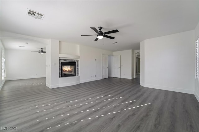 unfurnished living room featuring a multi sided fireplace and dark hardwood / wood-style floors