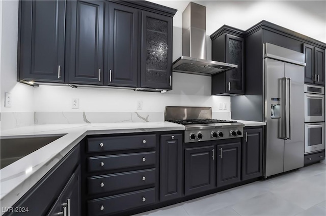 kitchen with stainless steel appliances, wall chimney exhaust hood, and light tile patterned flooring