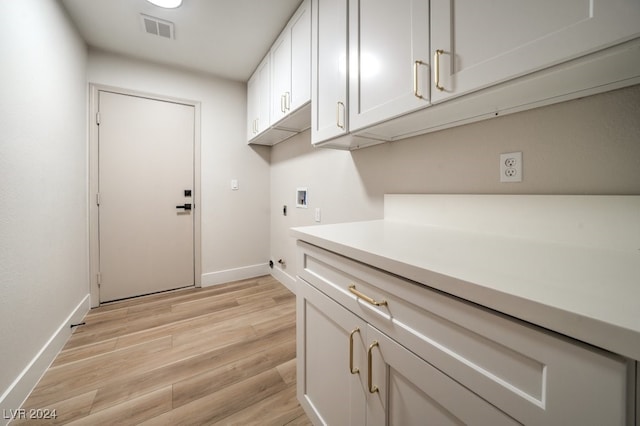 laundry area featuring cabinets, hookup for a washing machine, light hardwood / wood-style floors, and hookup for an electric dryer