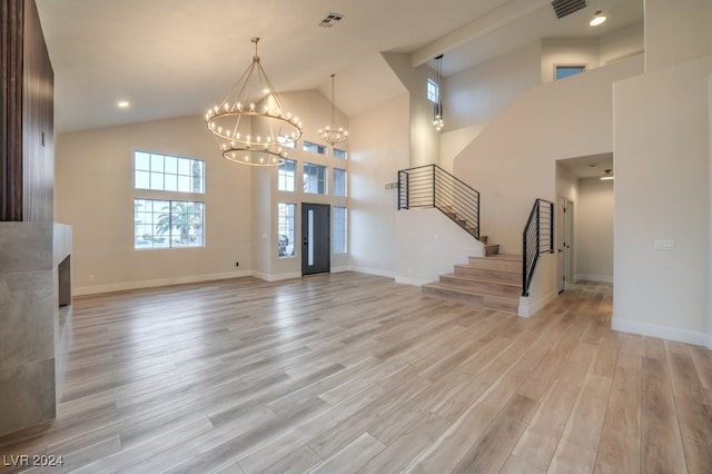 entrance foyer featuring a chandelier, high vaulted ceiling, and light hardwood / wood-style flooring