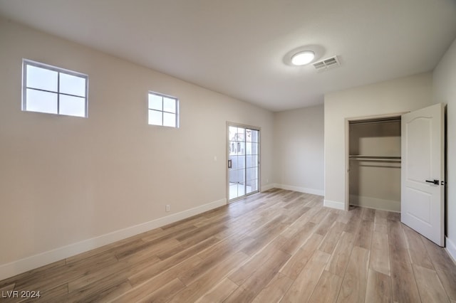 unfurnished bedroom featuring light wood-type flooring and a closet