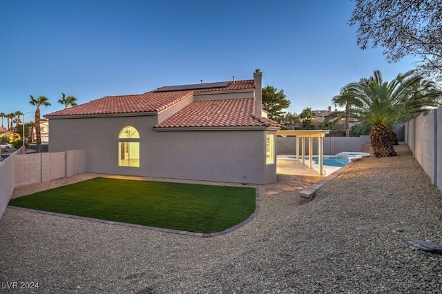 back of house with a fenced in pool and a patio