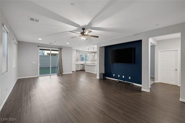 unfurnished living room featuring ceiling fan, dark hardwood / wood-style floors, and sink